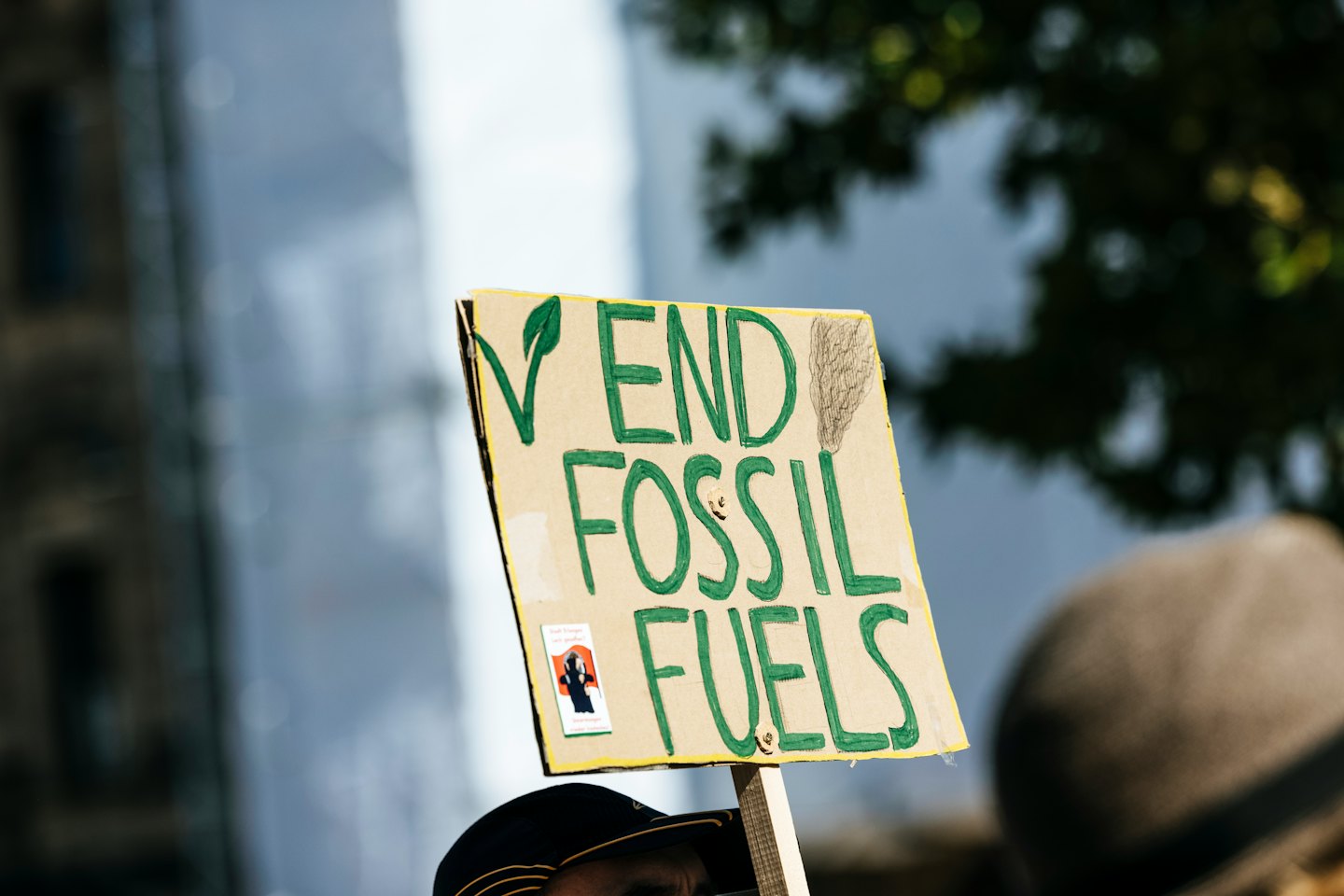 Handgemachtes Protestschild mit der Forderung nach einem Ende fossiler Brennstoffe.