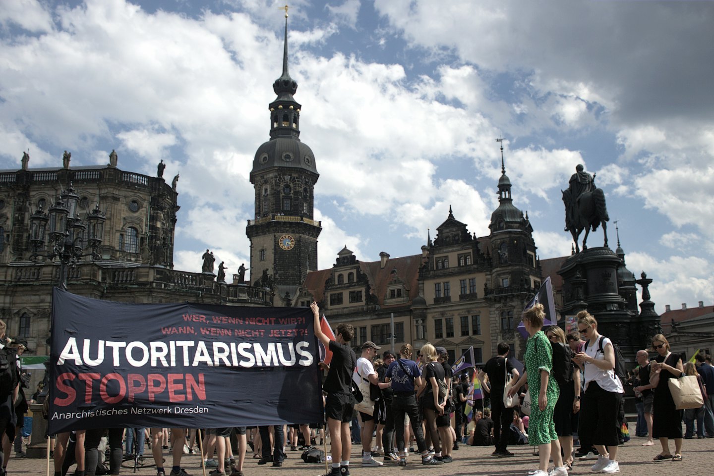 Menschen halten ein großes Deutschlandbanner auf einer Demonstration auf einem europäischen Platz.